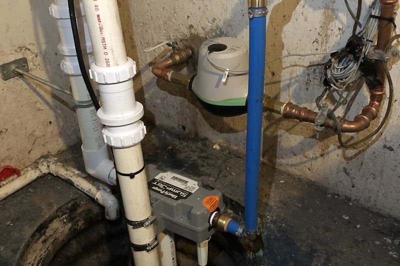 Basement sump pump with check valve and discharge line